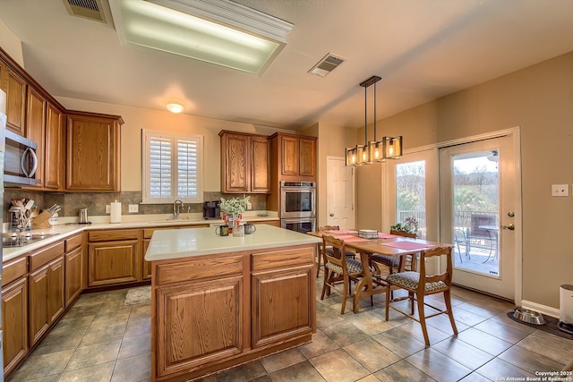 kitchen featuring stainless steel appliances, tasteful backsplash, a kitchen island, and visible vents