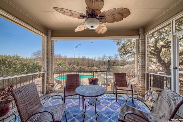 exterior space with a ceiling fan and a sunroom