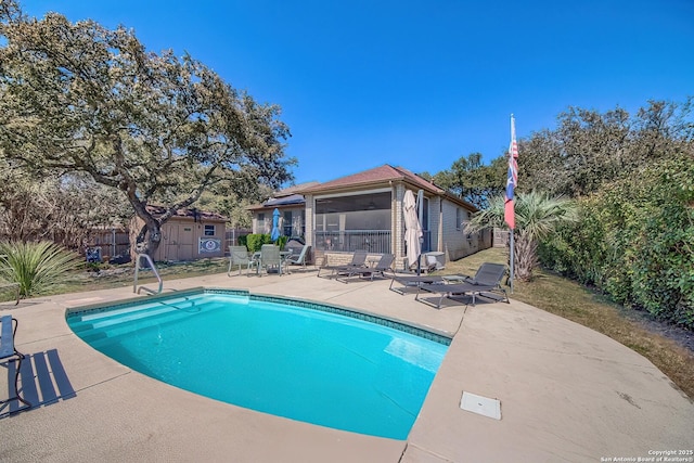 view of pool with a fenced in pool, a patio, an outbuilding, and a fenced backyard