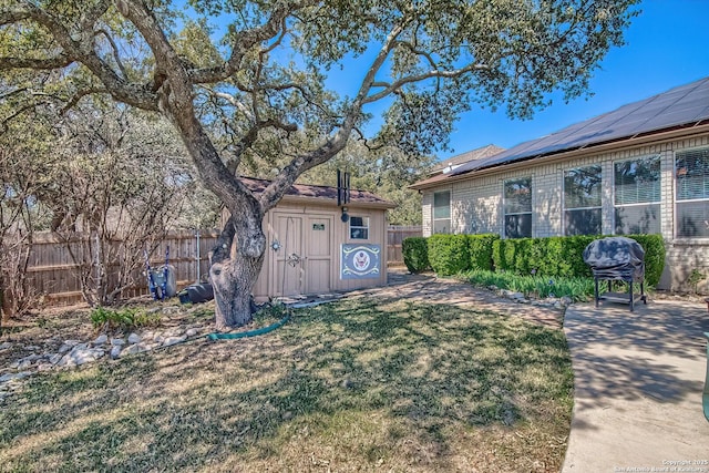 view of yard with a storage shed, an outdoor structure, and fence