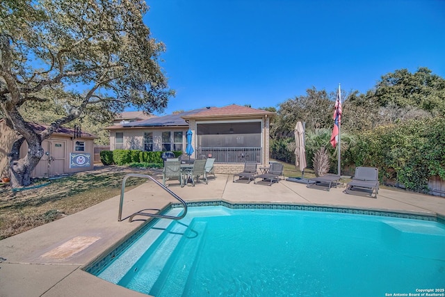 view of swimming pool featuring a patio area, a fenced in pool, and a sunroom