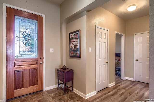 foyer with wood finished floors and baseboards