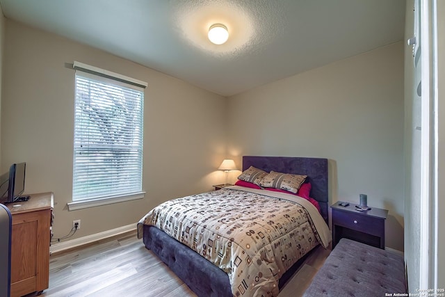 bedroom featuring light wood-type flooring and baseboards