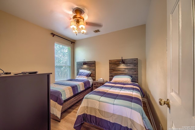 bedroom with visible vents, light wood-style flooring, and a ceiling fan