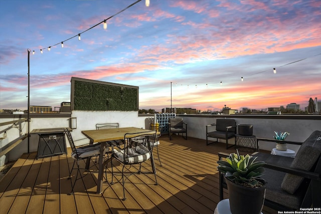 deck at dusk featuring outdoor dining area