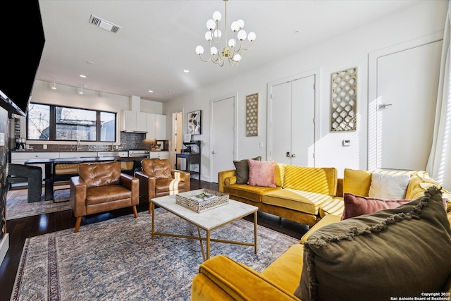 living area with visible vents, recessed lighting, an inviting chandelier, and wood finished floors