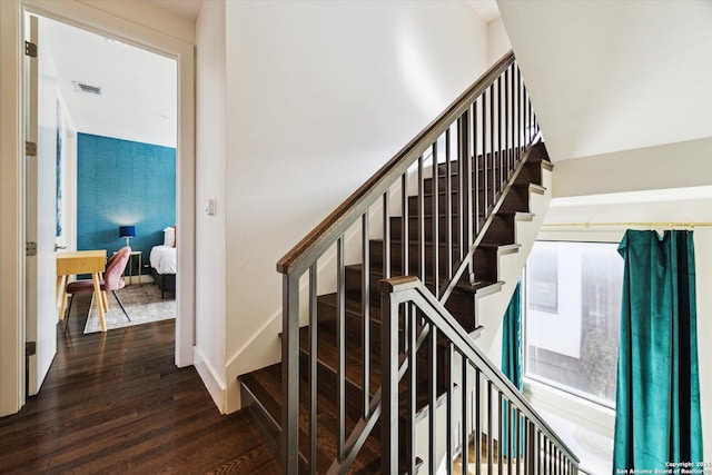 stairs with visible vents, baseboards, and wood finished floors