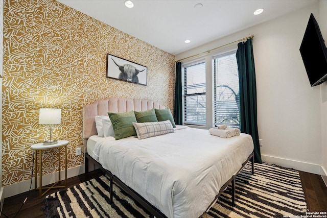 bedroom featuring recessed lighting, baseboards, wood finished floors, and wallpapered walls