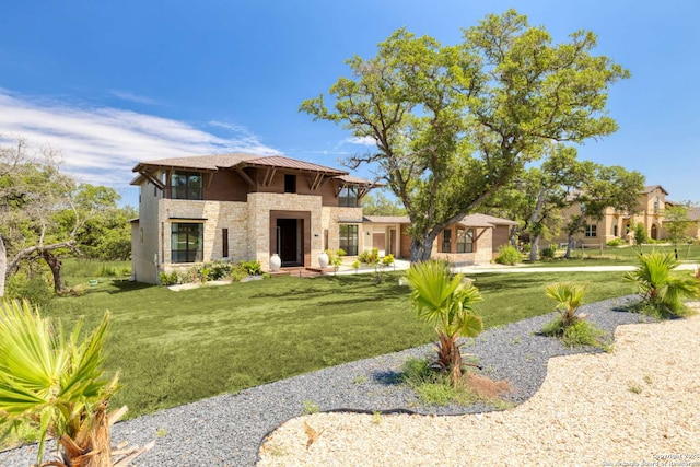 view of front facade with stone siding and a front lawn