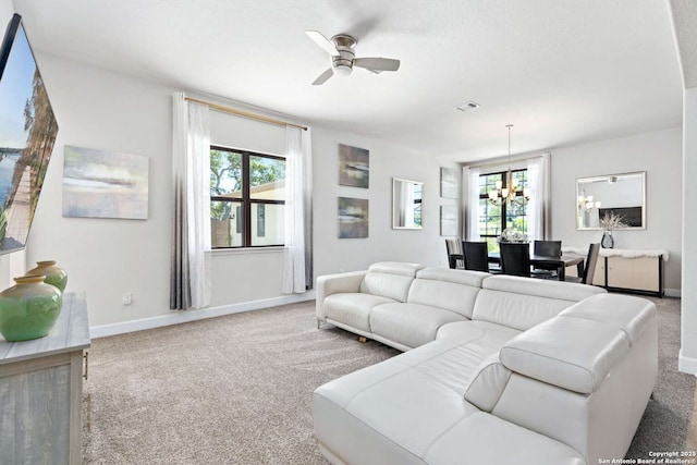 carpeted living area featuring visible vents, baseboards, and ceiling fan with notable chandelier