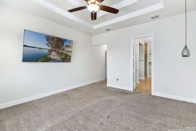 unfurnished bedroom with visible vents, crown molding, baseboards, carpet, and a tray ceiling