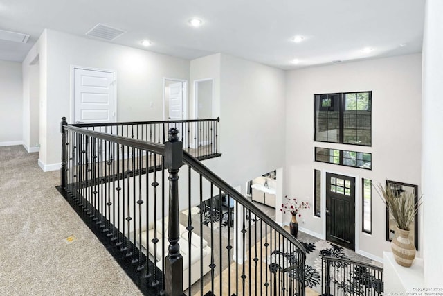 interior space with visible vents, recessed lighting, a high ceiling, and baseboards