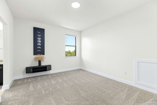 spare room featuring carpet flooring and baseboards