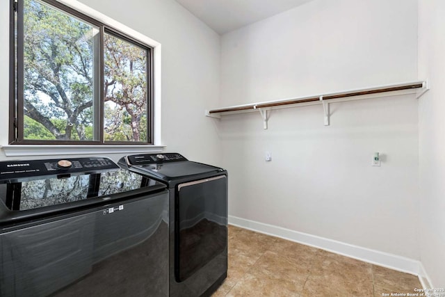 laundry area featuring baseboards, light tile patterned flooring, laundry area, and washer and clothes dryer