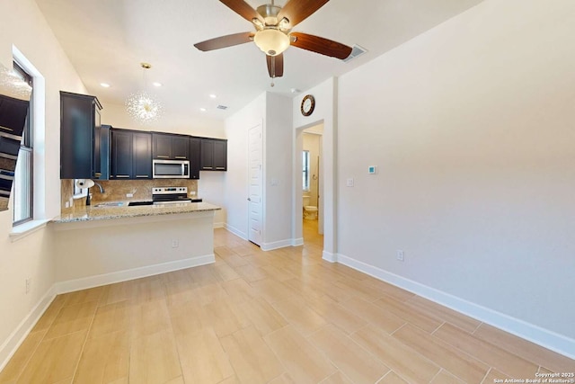 kitchen with visible vents, backsplash, a peninsula, stainless steel appliances, and a sink