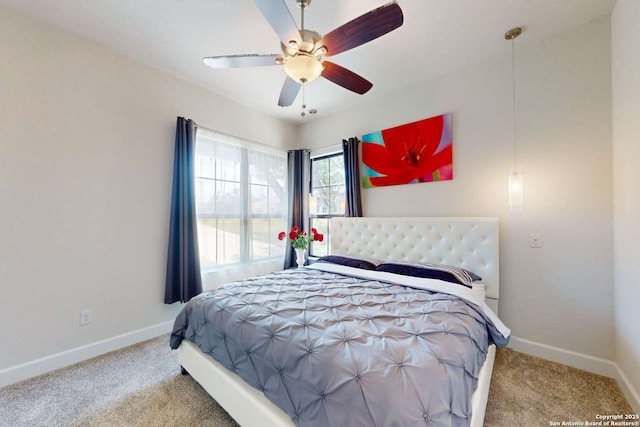 carpeted bedroom with a ceiling fan and baseboards