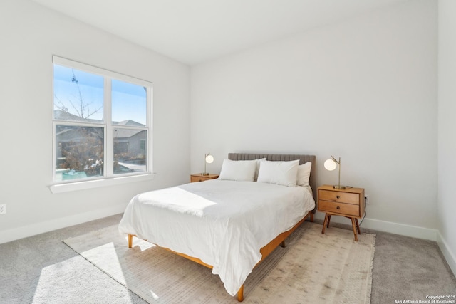 bedroom featuring light colored carpet and baseboards