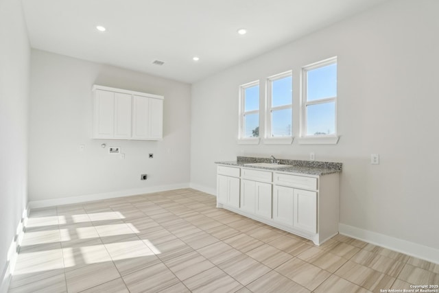 laundry room with baseboards, cabinet space, a sink, washer hookup, and electric dryer hookup