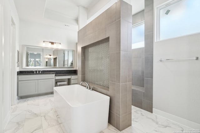 full bath featuring vanity, baseboards, marble finish floor, and a freestanding bath