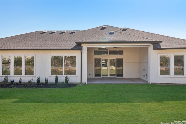 back of property with a patio, a lawn, and a shingled roof