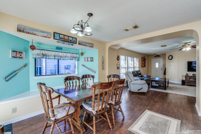 dining space with wood finished floors, visible vents, arched walkways, and baseboards