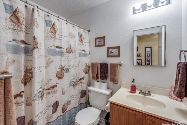 bathroom with vanity, curtained shower, toilet, and a textured ceiling