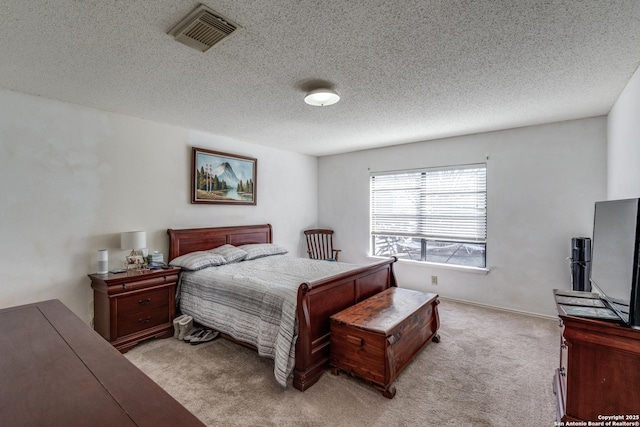 bedroom with light carpet, visible vents, and a textured ceiling