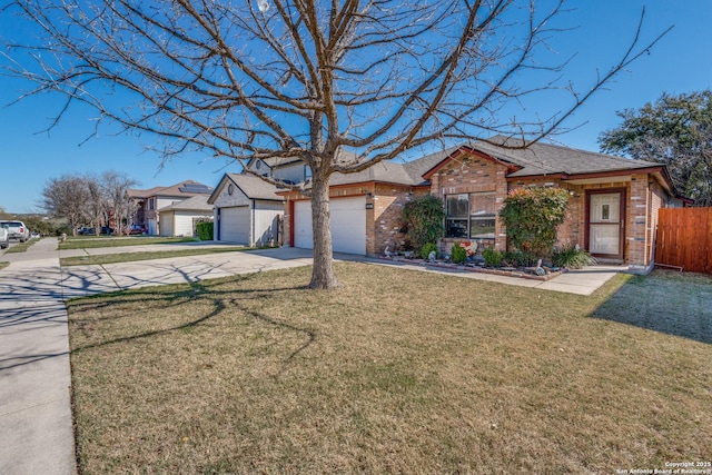 view of front of property featuring a front yard, fence, an attached garage, concrete driveway, and brick siding