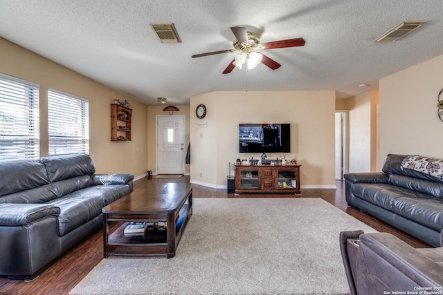 living room with visible vents, a textured ceiling, and wood finished floors