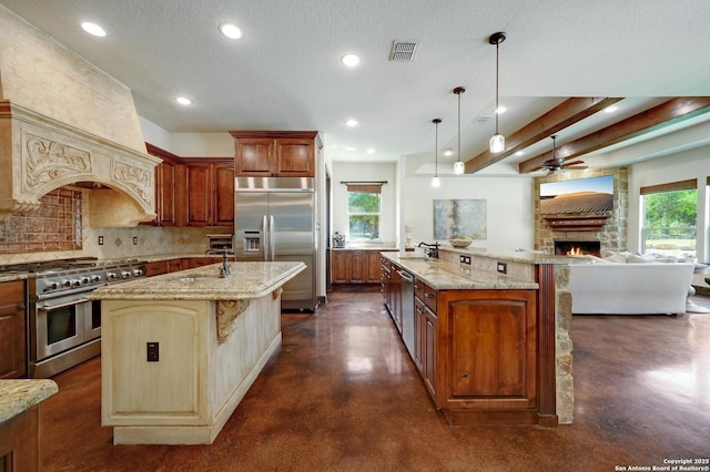133 Fair Spgs, Boerne, TX 78006 - kitchen featuring high quality appliances, a spacious island, finished concrete flooring, a stone fireplace, and recessed lighting