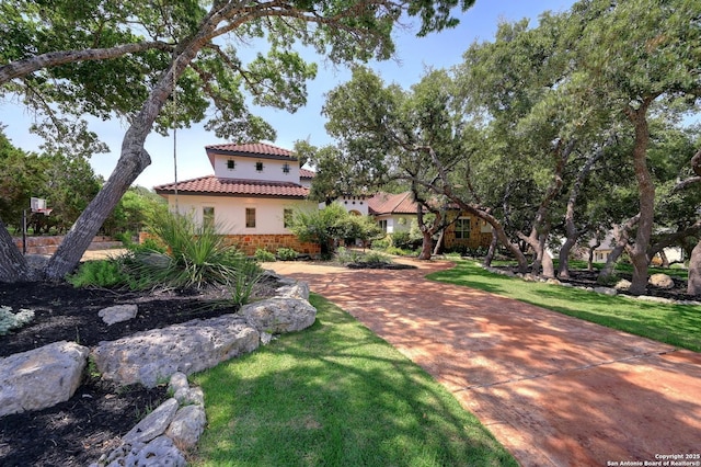 133 Fair Spgs, Boerne, TX 78006 - mediterranean / spanish-style house featuring stucco siding, a tile roof, a front lawn, and stone siding