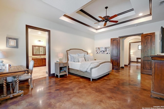 133 Fair Spgs, Boerne, TX 78006 - bedroom featuring concrete flooring, a raised ceiling, arched walkways, a sink, and ensuite bathroom