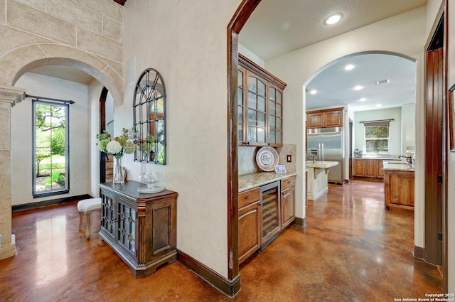 133 Fair Spgs, Boerne, TX 78006 - hall with beverage cooler, arched walkways, plenty of natural light, finished concrete floors, and recessed lighting