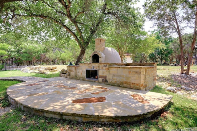 133 Fair Spgs, Boerne, TX 78006 - view of patio with an outdoor stone fireplace and view of scattered trees
