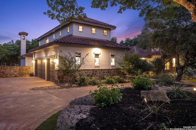 133 Fair Spgs, Boerne, TX 78006 - mediterranean / spanish house with stucco siding, concrete driveway, a tile roof, a garage, and stone siding