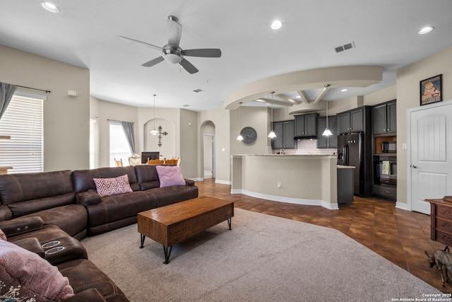 living room featuring visible vents, baseboards, ceiling fan, recessed lighting, and arched walkways