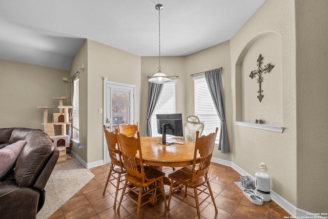 tiled dining space featuring baseboards