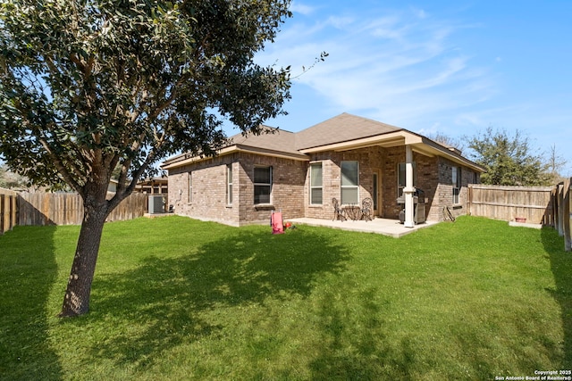 rear view of property featuring a patio, a fenced backyard, central AC, a lawn, and brick siding