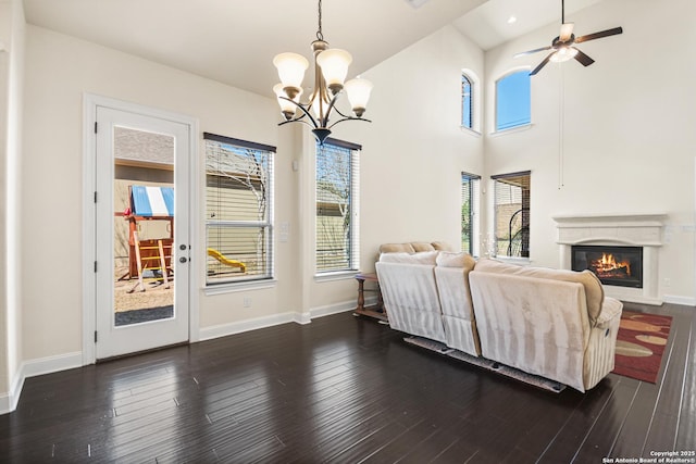 interior space featuring access to exterior, a glass covered fireplace, dark wood-type flooring, and baseboards