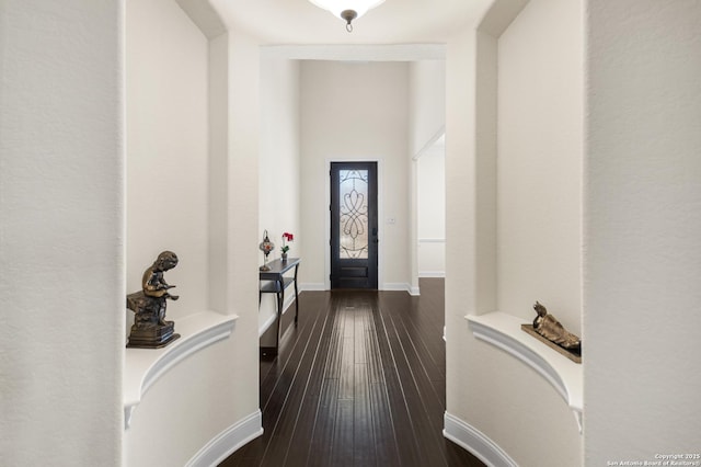 entryway with dark wood finished floors and baseboards