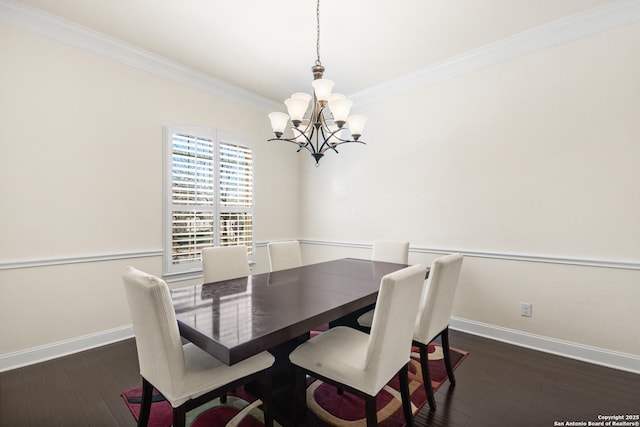 dining area featuring dark wood finished floors, an inviting chandelier, baseboards, and ornamental molding