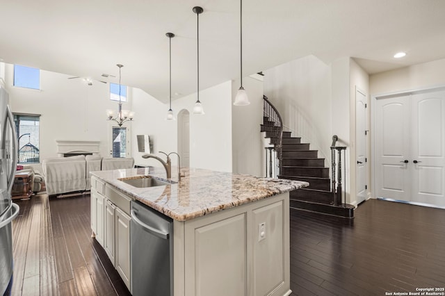 kitchen featuring a sink, open floor plan, appliances with stainless steel finishes, a fireplace, and dark wood-style flooring