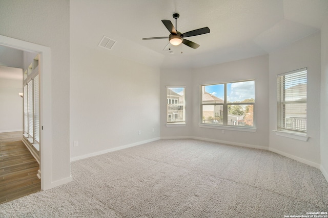 unfurnished room featuring carpet, baseboards, visible vents, and ceiling fan