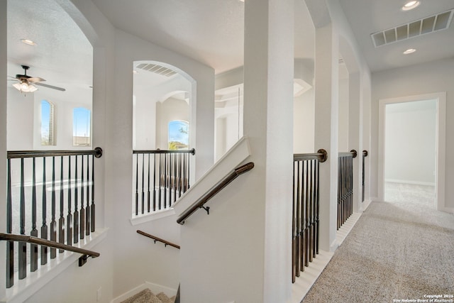 hallway featuring light carpet, visible vents, recessed lighting, and baseboards