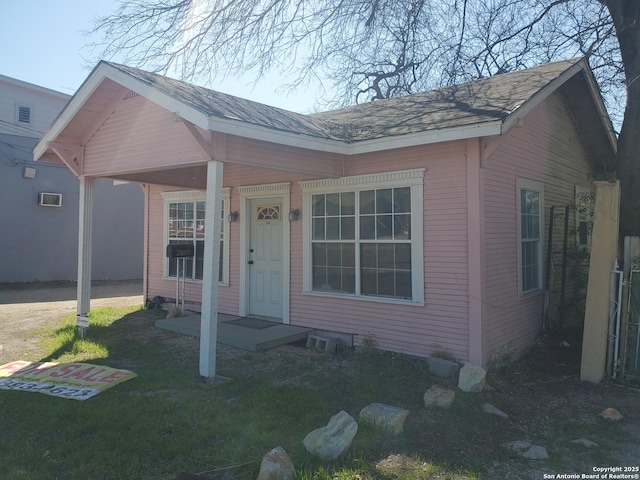 bungalow-style house featuring a front yard and a shingled roof