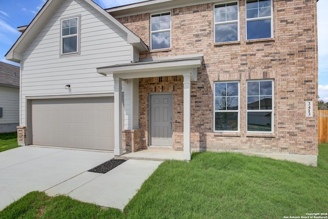 view of front facade with a front yard, a garage, brick siding, and concrete driveway