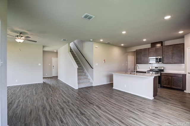 kitchen featuring visible vents, a center island with sink, open floor plan, dark wood-style floors, and appliances with stainless steel finishes