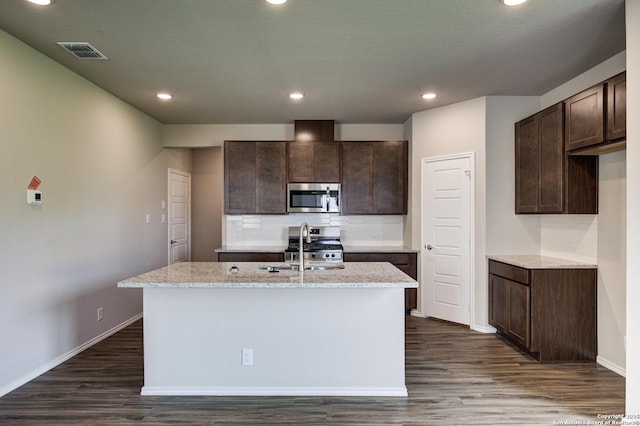 kitchen with dark brown cabinetry, visible vents, dark wood-type flooring, and stainless steel appliances