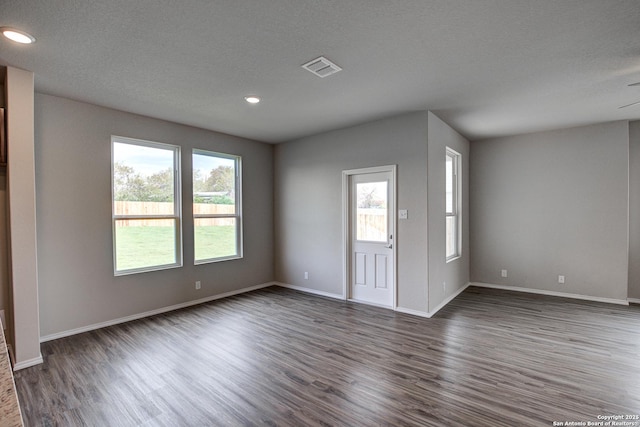 interior space featuring plenty of natural light, baseboards, and dark wood-style flooring