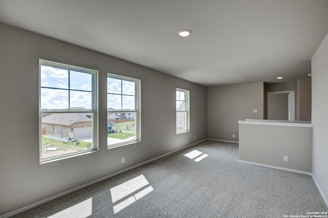 carpeted spare room featuring baseboards